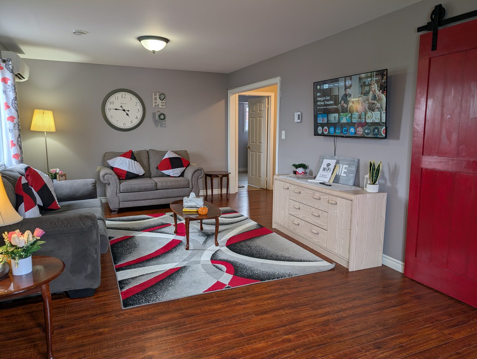 Living room with sofas, TV, and Wi-Fi info sign